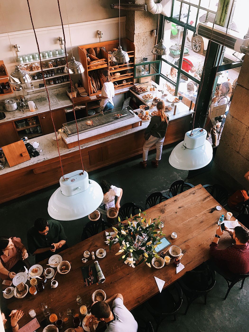 Overhead view of a busy cafe with guests at a long communal table